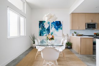 The dining room is outfitted with a pair of striking paintings by Vivian Caits.