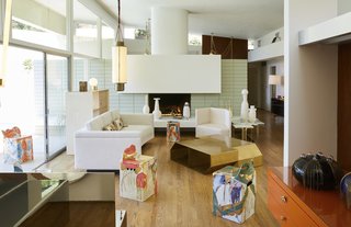 The bright and airy gallery space—featuring a contemporary fireplace, sliding glass doors, and a backyard pool—serves as the perfect setting for Sanguino's work. 