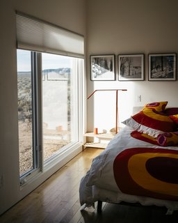 A Rookie Designer and Her Builder Father Create an Artist's Sculptural Loft in the Desert - Photo 6 of 10 - "It was important to Lois that the outside come inside," says Molly, who designed the master bedroom to maximize the views. "The windows make you feel like you’re in a sea of sagebrush." The Equo Gen 3 LED floor lamp is from YLighting.