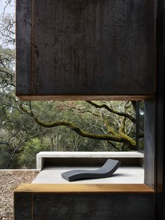 Nature Drove the Design of This Sculptural, Cor-Ten Steel House in Northern California - Photo 12 of 13 - An opening in a Cor-Ten steel—clad wall on the terrace frames the Paola Lenti chaise longue. 