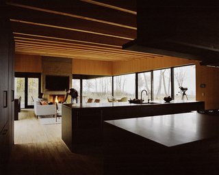 Plagued Ash Trees Were Repurposed to Create This Charred-Cedar Clad Home on Lake Michigan - Photo 6 of 9 - The residents went with a Control4 automation system to handle lighting, sound, and window shades; Traverse City–based Waara Technologies did the installation. A fireplace designed by Desai Chia and built by BRD anchors the living area. 