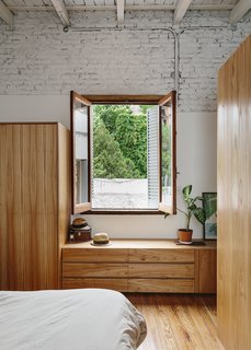 An Architect Turns His Small, Dark Apartment in Buenos Aires Into a Bright and Airy Home - Photo 5 of 10 - Demolition exposed a high, wood-beamed ceiling, which added "cubic meters of air" to the apartment, says Hernán. The bedroom is furnished with custom pieces made of Paraiso wood. 