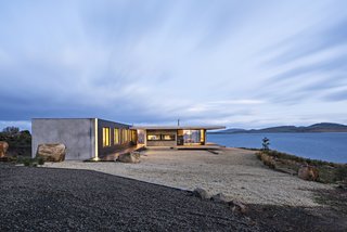 The Younger family vacation home is a semi-modular structure made of wood, steel, glass, and precast concrete. It’s surrounded by Tasman gold gravel, which acts as <br>a buffer zone in case of a bushfire. A building-height LED light accentuates an exterior corner. Styled by Julia Landgren