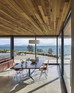 The dining table and chairs are by Charles and Ray Eames. The ceiling, which extends beyond the building’s envelope, is made of Tasmanian oak. Styled by Julia Landgren