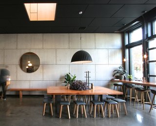 Large communal tables, sound-absorbing ceiling tiles, and street-side seating create a cozy atmosphere. 
