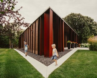 Owners Rachel and Nolan Ploegman's sons, Alex and Logan, run along the perimeter of their Parallelogram House in Winnipeg, Manitoba. Its raw shell and stretched geometry were conceived by 5468796 Architecture and executed by Concord Projects. Brunswick Steel assisted with the bent-plate Cor-Ten columns.