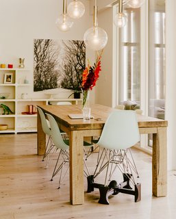 One of the Eames Molded Plastic chairs is lifted on a Kaboost base so that a child can eat at the dining table. 