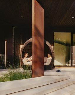 Rachel reclines in a daybed on the patio outside the master bedroom.