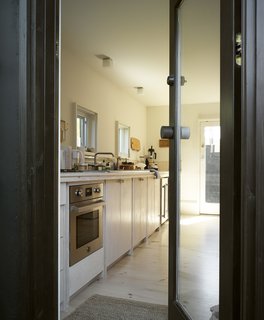 The kitchen features Douglas fir cabinets that Samantha built on-site, a move that helped her complete the project at a cost of $145 per square foot.