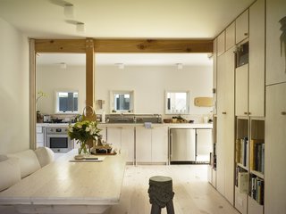 In contrast to the dark, almost monolithic exterior, the interior is full of light, thanks in part to the whitewashed woodwork and floors. "Because the space is so small, I felt I needed to allow the light to travel all over," says Samantha. The undercounter refrigerator and freezer are by Summit Appliance. Much of the furniture, like the dining table, is built-in.