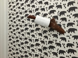 The toilet paper holder is a piece of a madrone tree. Waldman and team installed a bear wallpaper by Andrea Lauren on Etsy. Make sure to dust and clean the wall extremely well before installing wallpaper, and use one of those $1 plastic scrapers to work the air bubbles out.