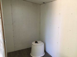 Here, the interior walls are going up. The left wall is given lauan plywood (since it's going to be covered in wallpaper) and the other walls are covered in beadboard. 