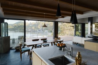 The kitchen features Japanese ash casework and Jacques Biny lights, made in 1956. A Semi pendant by Gubi hangs above a De La Espada table.