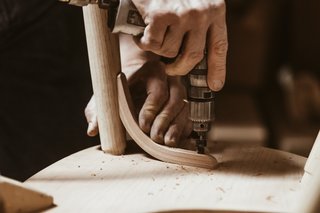 Watch: It Takes 9 Hours For Woodworkers to Make This Shaker-Inspired Chair - Photo 18 of 19 - Attach the Knees: Replacing ordinary stretchers, laminated cherry "ship’s knees" fit into a specially routed mortise in each leg. Once they’ve been glued, clamped, and screwed into the seat and legs, they’re rasped and sanded.