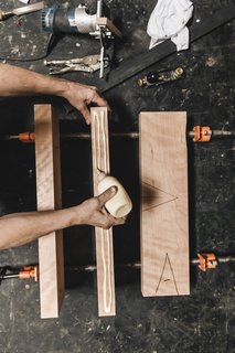 Watch: It Takes 9 Hours For Woodworkers to Make This Shaker-Inspired Chair - Photo 10 of 19 - Cut and Glue: A six-foot cherry board is cut into three pieces and passed over the jointer to get a flat face and a perpendicular edge. The pieces are color- and grain-matched and glued together<br>to form an 18-by-24-inch panel that will become the chair’s seat. 