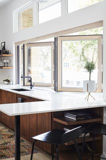 Midcentury Mashup: A 1950s Ranch House in Chicago Gets a Palm Springs-Style Butterfly Roof - Photo 2 of 15 - A 14-foot-wide opening defines the kitchen, which architect Scott Delano, with Nicholas Pettit, carved out of what had been an enclosed breezeway and part of the garage. The bifold window is from NanaWall, the windows above are by Pella, and <br>the faucet is by Blanco. 
