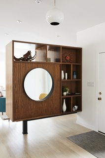 Midcentury Mashup: A 1950s Ranch House in Chicago Gets a Palm Springs-Style Butterfly Roof - Photo 6 of 15 - To break up the long living room, Pettit created a walnut bookcase near the entrance.
