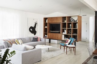 Midcentury Mashup: A 1950s Ranch House in Chicago Gets a Palm Springs-Style Butterfly Roof - Photo 8 of 15 - A sectional designed by the residents joins a coffee table that Trey devised out of marble left over from a bathroom floor. The teak lounge chair by S.A. Andersen & Erik Andersen and Palle Pedersen for Horsnaes Møbler and the Jens Risom side table are both vintage. The painting is by Wesley Kimler. 