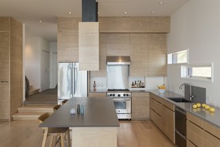 Fabricated by Mancuso Construction, the ash kitchen cabinets were cut across the grain and installed so that the pattern matches continuously from unit to unit. 
