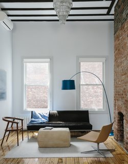 On the top floor, a Cumberland chair by Thos. Moser faces a Room & Board ottoman, a Twiggy lamp by Foscarini, and a vintage sofa upholstered in cowhide. 