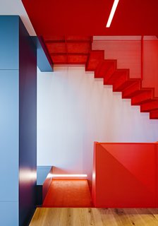 After a Renovation, a Classic San Francisco Victorian Is Now Bursting With Light and Color - Photo 1 of 15 - A perforated-metal staircase in Benjamin Moore’s Flame and built-in cabinetry in various shades of blue highlight Fougeron Architecture’s bold reinvention of a narrow row house in Noe Valley for a couple and their daughter. 