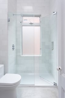Polished concrete floors and oversized quartz marble subway tiles outfit the second floor bathroom.