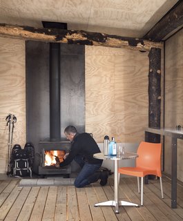 A wood stove completes the enclosed room of the structure. Just two rooms make up The Phoenix: one open room and this enclosed room, home to minimal storage.