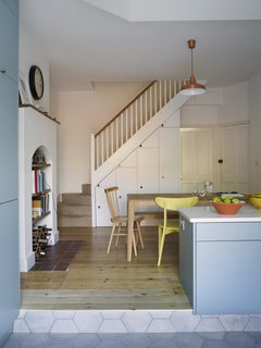 In the dining area, built-in storage was added beneath the staircase. The table is by Ebbe Gehl for John Lewis and the pendant is by Anglepoise. 
