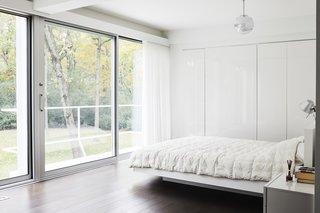 Once Covered in Mold, a Midcentury Gem Outside Chicago Is Reborn - Photo 9 of 15 - All of the existing windows were replaced with newer versions by the company that did the originals, Arcadia. The master bedroom and bathroom are located where the kitchen and dining area once were. The floating bed is by TemaHome and the Mirror Ball pendant is by Tom Dixon. 
