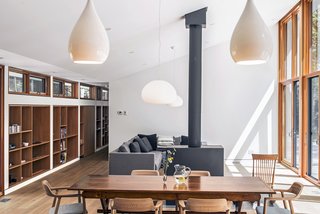 The furniture is a combination of family heirlooms and newer items, such as the Hiroshima Woodseat armchairs by Naoto Fukusawa for Mjolk that surround the dining table. Two Glo-Ball pendants by Jasper Morrison hang in the living/dining area, while Drop 1 pendants by Peter Bowles light the kitchen. 