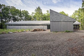  A perpendicular wing houses the garage. The house has no air conditioning, relying on lake breezes and cross-ventilation for cooling. Each bedroom has a screened door that opens to the deck and an adjustable transom above the hallway door to encourage the circulation of air.