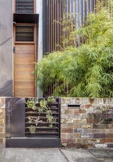 A Sustainable Home Near Sydney Boasts Chicken Coops, Vertical Gardens, and More - Photo 1 of 9 - The gate leading to Geoff Carroll and Julie Young’s rebuilt terrace house in an inner suburb of Sydney, Australia, holds an array of succulents, signaling what lies within: a greenery-filled home that includes a central courtyard, vertical gardens, aquaponics and rain filter systems, and even a chicken coop. Architect Clinton Cole of CplusC Architectural Workshop led a team of collaborators in revamping the property.