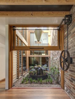 A Sustainable Home Near Sydney Boasts Chicken Coops, Vertical Gardens, and More - Photo 2 of 9 - A counterweight pulley system makes easy work of lifting the large glazed walls flanking the courtyard.