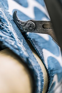 <b>10 Trim the Selvedge</b> As the loom weaves, the fabric continuously advances forward and is rolled onto a beam<br>at the front of the loom. As it rolls out, cutters trim the edges, creating the textile’s finished width. 