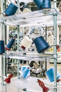 <b>7 Introduce Color</b> The warp, which is made of thousands of fine yarns, acts as a "carrier" for the blue and off-white cotton weft yarns. The binary file controls how and when the warp threads are manipulated to make way for the weft yarn. 