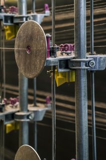 <b>4 Create Tension</b> Tidal Wave has a two-color warp made from fine, solution-dyed nylon yarn. Each individual yarn is run through a device that keeps it from getting tangled and ensures uniform tension as it winds around a huge drum. 
