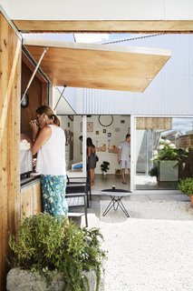 This DIY Home in New Zealand Doubles as a Coffee Spot and Art Gallery - Photo 3 of 16 - Grant built the steel-and-cypress gate. On the other side, he set up his coffee kiosk and art gallery.