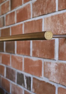 This DIY Home in New Zealand Doubles as a Coffee Spot and Art Gallery - Photo 15 of 16 - <b>Door Pulls & Lights:</b> Grant made many of the light fixtures and door pulls himself using brass tubing. For the lights, he realized that a New Zealand dollar coin was the perfect size for the end caps, a discovery that saved him $36 on store-bought versions.