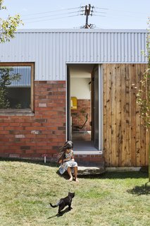 This DIY Home in New Zealand Doubles as a Coffee Spot and Art Gallery - Photo 7 of 16 - In the middle courtyard, the Jacks landscaped a small grass mound for Sadie, five, to play on. The house is topped with corrugated steel. "It’s essentially the cheapest material you can get for roofing in New Zealand," says Beer.