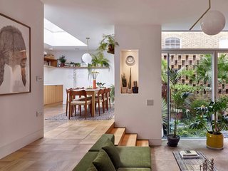 The living area boasts nearly 10-foot-high ceilings that impart a feeling of airiness and spaciousness. Discreet, built-in storage in the floor at the top of the steps prevents clutter from accumulating. 