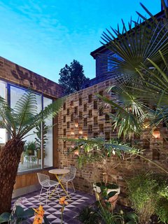 The exterior courtyard's tile floor mimics the tile treatment at the entry for cohesion, and the perforated brickwork creates a lovely pattern when backlit at night.