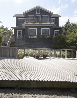 Three-quarters of a century after it was built, a beach home in Saltaire, New York, was elevated eight feet and enlarged by adding a new second story. Its cedar shingles were coated in Benjamin Moore's Westcott Navy 1624. 