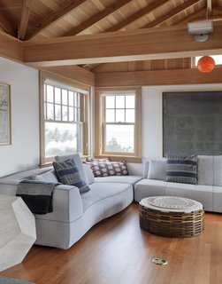 A Bend Sofa by Patricia Urquiola for B&B Italia commands one corner of the second floor; joining it is a Maria Preciosa coffee table by Etel Carmona. A vintage red Italian pendant hangs overhead.