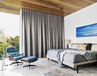 Cover Story: This House in Austin Has a Tree Growing Right Through It - Photo 8 of 10 - Drapes by Cush Cush Design offer privacy in the master bedroom. An Andy Moses painting hangs above the bed. 