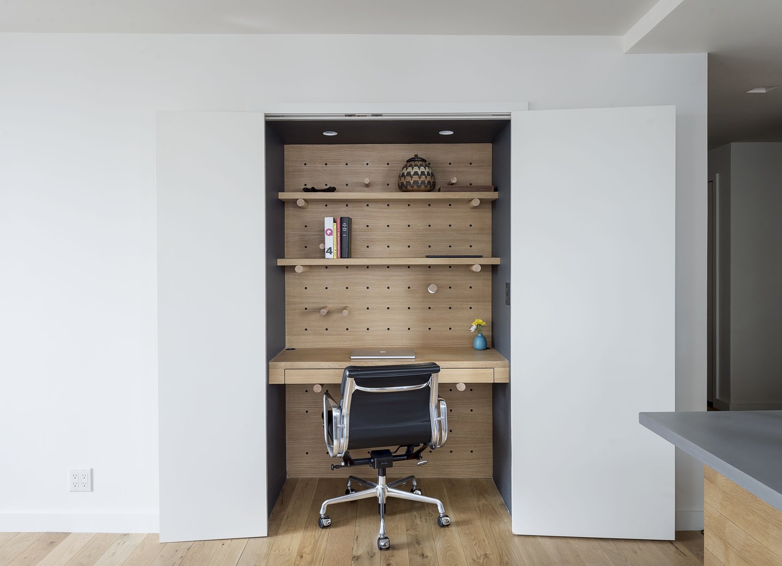 Adjustable pegboards help lawyer Dan Franklin manage his compact apartment in downtown Manhattan. The Executive Chair is by Charles and Ray Eames for Herman Miller.