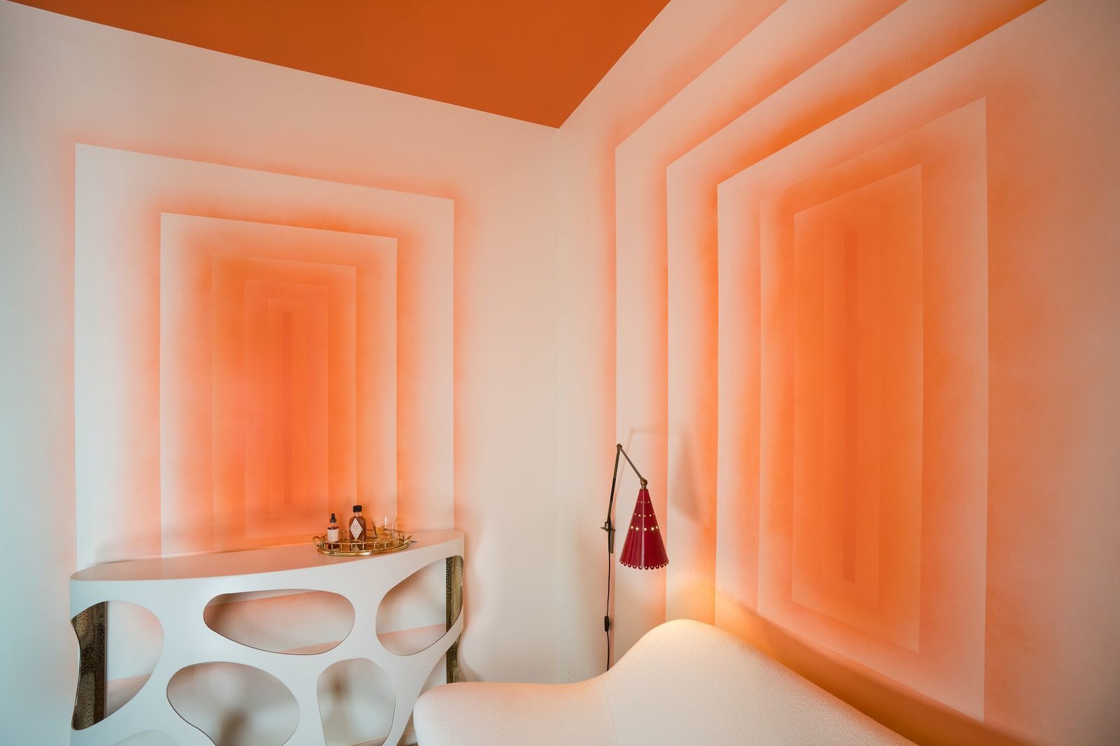 Decorative artist Willem Racké worked with Susan Chastain to create this vibrant tangerine lounge. The two main walls of the small room were painted to give the illusion of looking into infinity. A high-gloss, orange lacquer covers the ceiling.