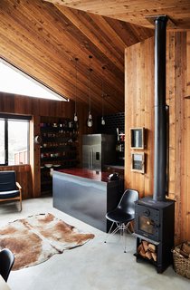 The island countertop material is from recycled railway sleepers and the sides are custom clear-coated steel. The appliances are by Fisher & Paykel.