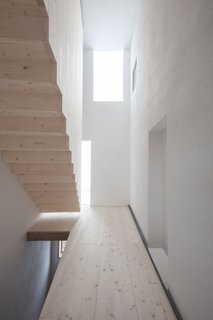 The floating spruce staircase is housed in a new tower-like volume.