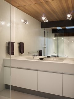 Designer Lisa Chadbourne created a "massive" look in this bathroom with a large format slab of Caesarstone premium quartz for the counters."We clad the whole thing in stone," says Lisa Chadbourne. The large slabs allowed for a literally seamless look.