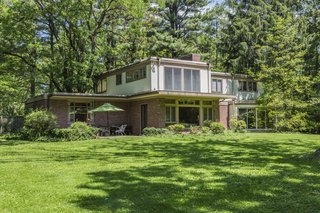 The home’s stone patio sits on the idyllic, emerald-green back yard. 